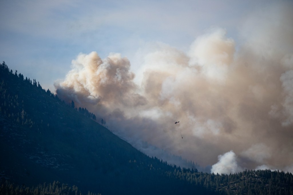 A helicopter dropping water on the Davis Fire